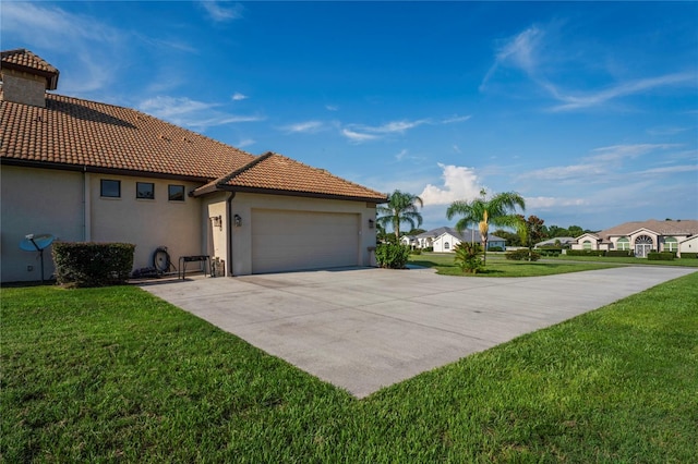 view of side of home featuring a garage and a yard