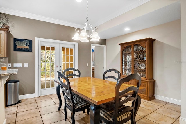 dining space featuring a notable chandelier, ornamental molding, french doors, and light tile patterned flooring