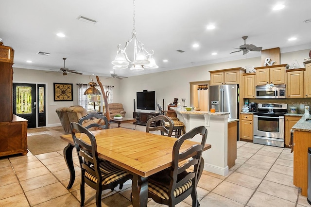 dining room with ceiling fan with notable chandelier, ornamental molding, and light tile patterned flooring