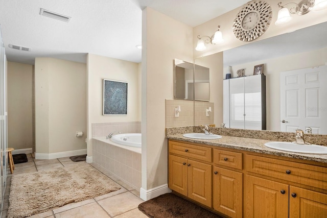 bathroom featuring tiled tub, decorative backsplash, tile patterned floors, and vanity