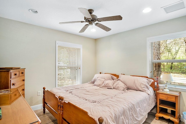 tiled bedroom with ceiling fan and multiple windows