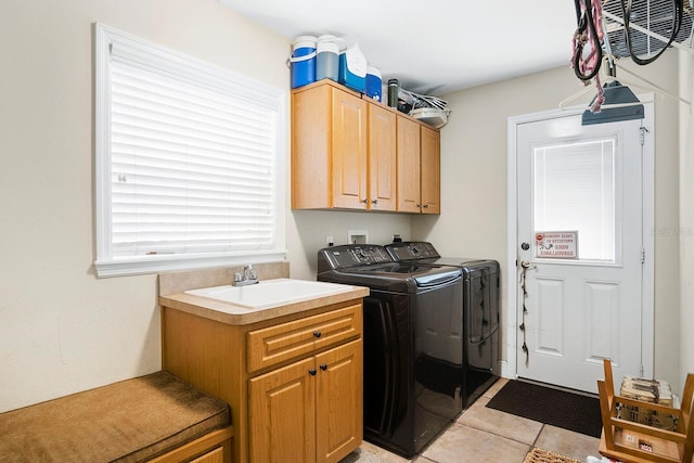 clothes washing area with sink, light tile patterned floors, cabinets, and independent washer and dryer