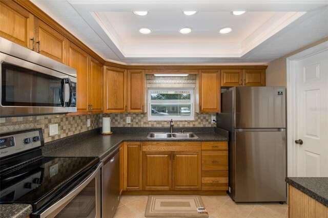 kitchen featuring sink, light tile patterned floors, a raised ceiling, and stainless steel appliances