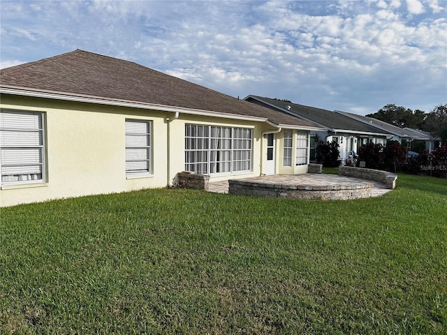 4713 Tiburon Dr, New Port Richey, FL 34655 - back of property with stucco siding, a lawn, a patio, and a shingled roof