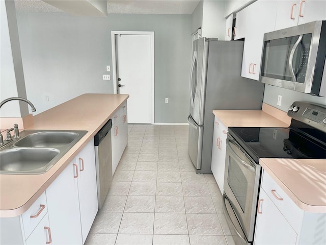 4713 Tiburon Dr, New Port Richey, FL 34655 - kitchen featuring white cabinets, stainless steel appliances, light countertops, and a sink