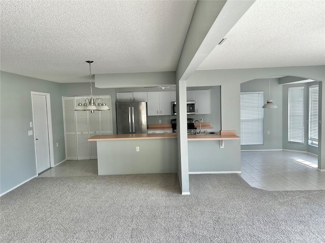 4713 Tiburon Dr, New Port Richey, FL 34655 - kitchen with a textured ceiling, appliances with stainless steel finishes, and light carpet
