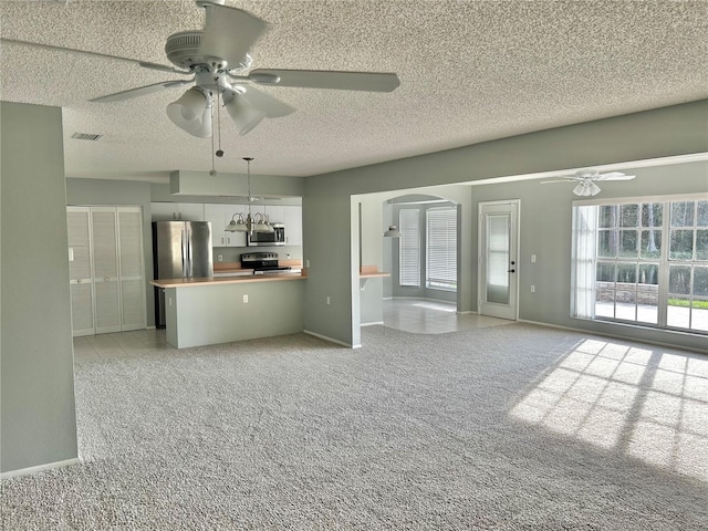 4713 Tiburon Dr, New Port Richey, FL 34655 - unfurnished living room with arched walkways, light colored carpet, baseboards, visible vents, and a ceiling fan