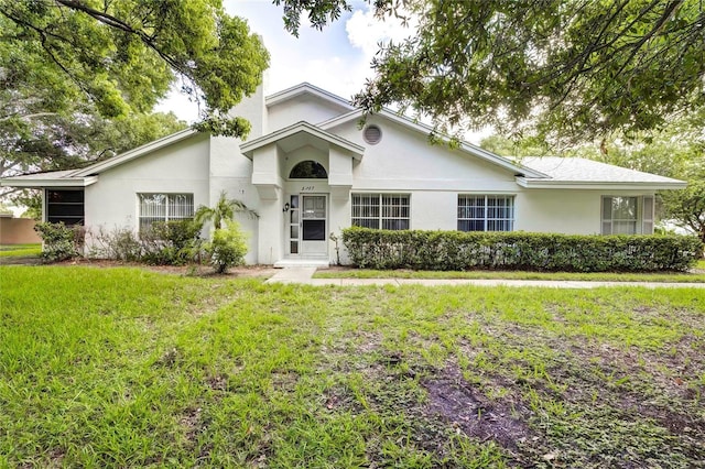 ranch-style house featuring stucco siding and a front lawn