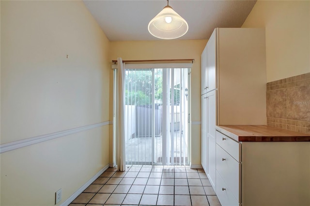 doorway to outside with light tile patterned floors