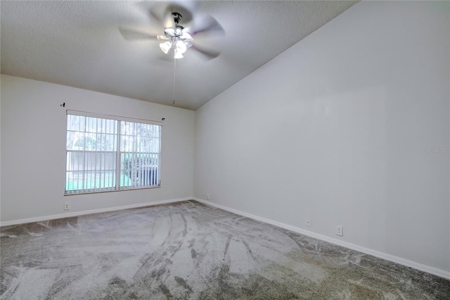 carpeted empty room featuring ceiling fan and vaulted ceiling