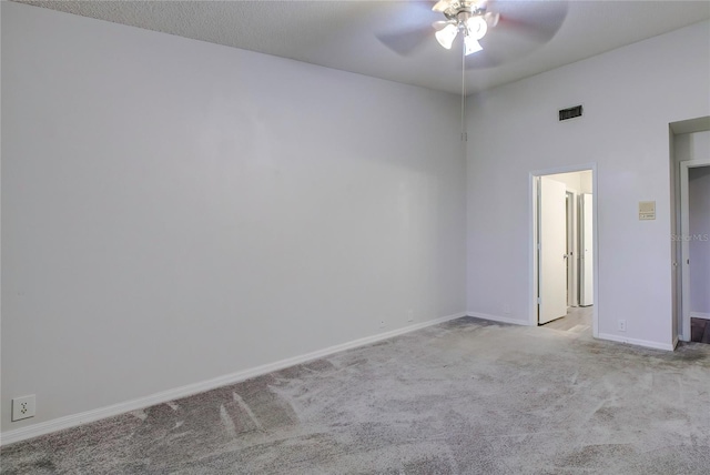 empty room featuring ceiling fan and light carpet