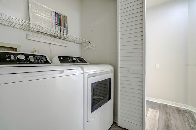 clothes washing area featuring light hardwood / wood-style flooring and separate washer and dryer