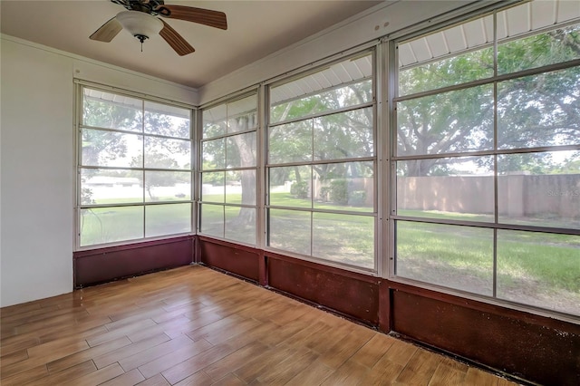 unfurnished sunroom with ceiling fan and plenty of natural light