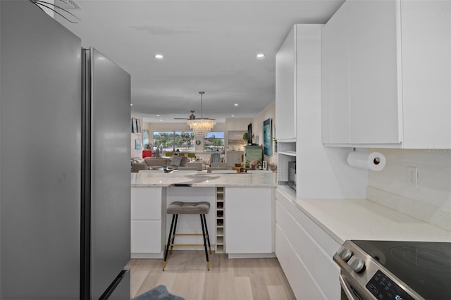 kitchen featuring modern cabinets, recessed lighting, appliances with stainless steel finishes, white cabinets, and light wood finished floors