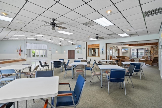 carpeted dining space featuring a paneled ceiling, visible vents, a wealth of natural light, and ceiling fan