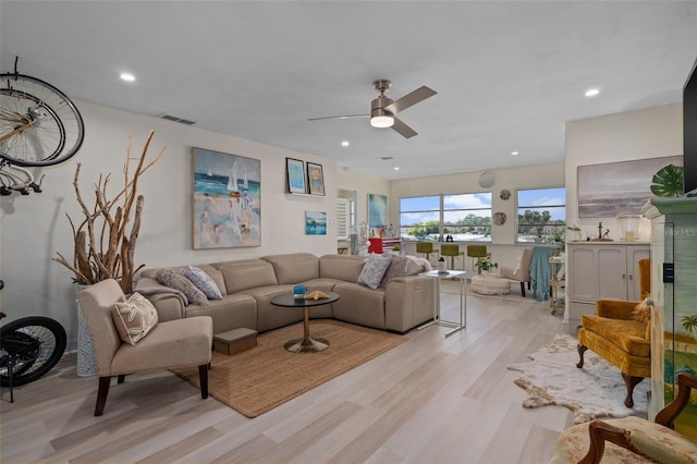 living room with ceiling fan and light hardwood / wood-style flooring