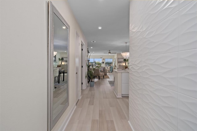 corridor featuring light wood-style flooring and recessed lighting