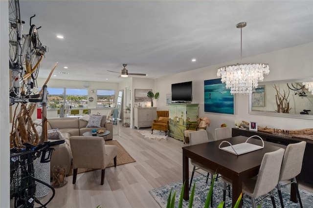 dining area with ceiling fan with notable chandelier, recessed lighting, and wood finished floors