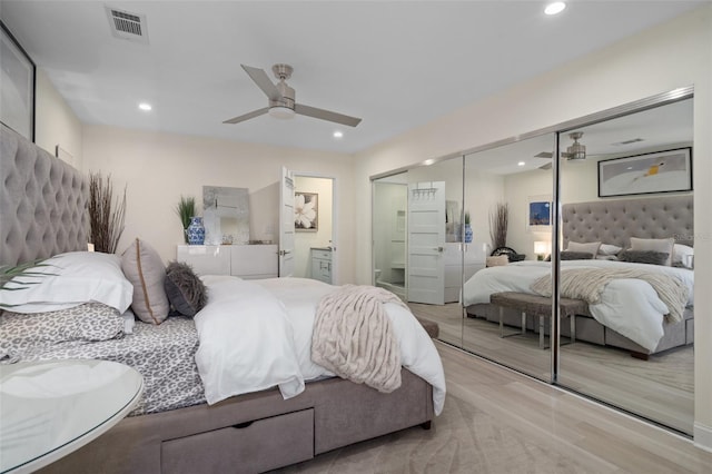 bedroom with wood finished floors, recessed lighting, visible vents, and a closet