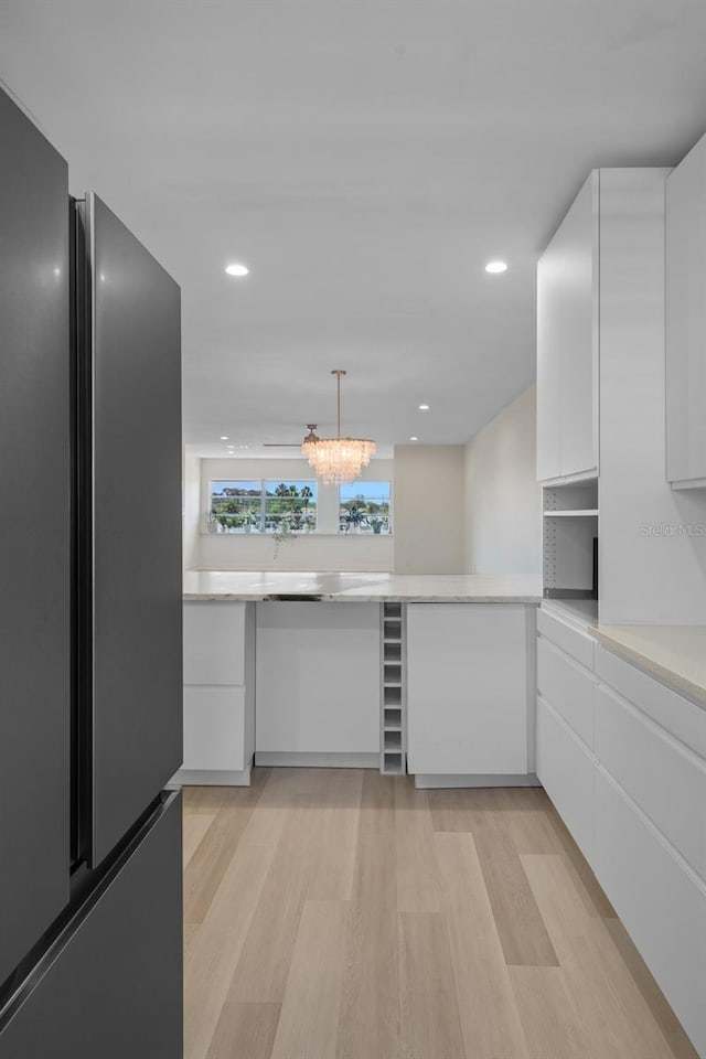 4632 Marine Pkwy Unit 302, New Port Richey, FL 34652 - kitchen with freestanding refrigerator, light wood finished floors, light countertops, white cabinetry, and recessed lighting