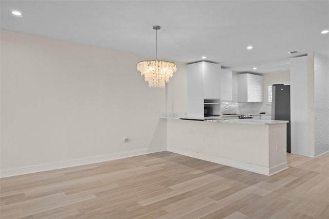 4632 Marine Pkwy Unit 302, New Port Richey, FL 34652 - kitchen with freestanding refrigerator, light wood-style flooring, white cabinetry, light countertops, and recessed lighting