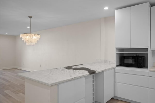 4632 Marine Pkwy Unit 302, New Port Richey, FL 34652 - kitchen featuring black microwave, a peninsula, light wood-type flooring, white cabinetry, and recessed lighting