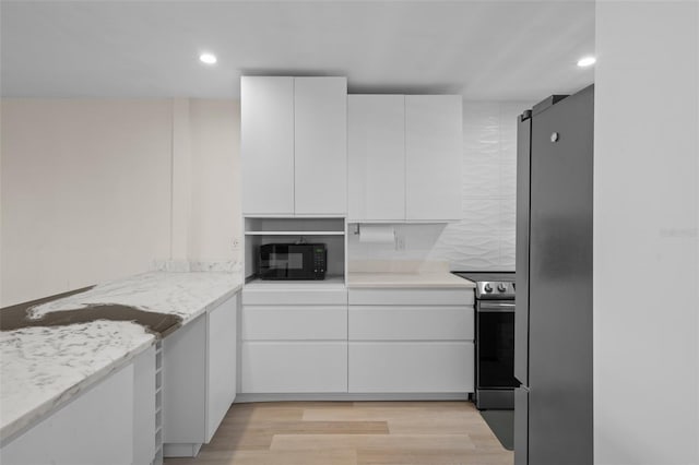 4632 Marine Pkwy Unit 302, New Port Richey, FL 34652 - kitchen featuring appliances with stainless steel finishes, white cabinets, light wood-style floors, and recessed lighting