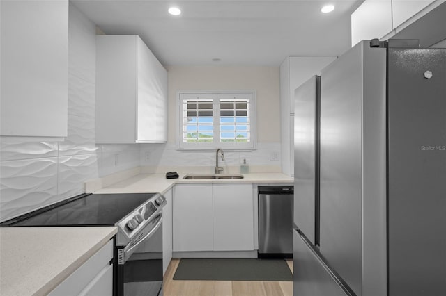4632 Marine Pkwy Unit 302, New Port Richey, FL 34652 - kitchen with appliances with stainless steel finishes, a sink, white cabinets, light countertops, and backsplash