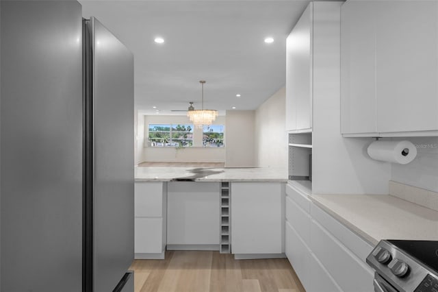 4632 Marine Pkwy Unit 302, New Port Richey, FL 34652 - kitchen featuring appliances with stainless steel finishes, white cabinetry, light wood-style floors, recessed lighting, and decorative light fixtures