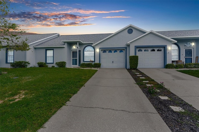 ranch-style house featuring a garage and a yard