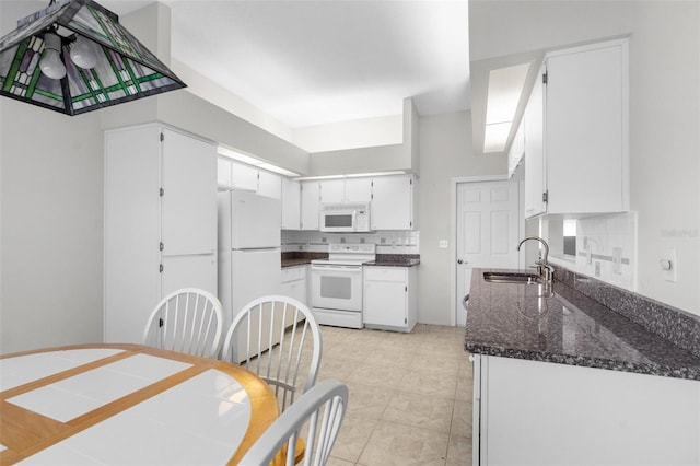 kitchen with dark stone countertops, white appliances, light tile patterned floors, backsplash, and sink