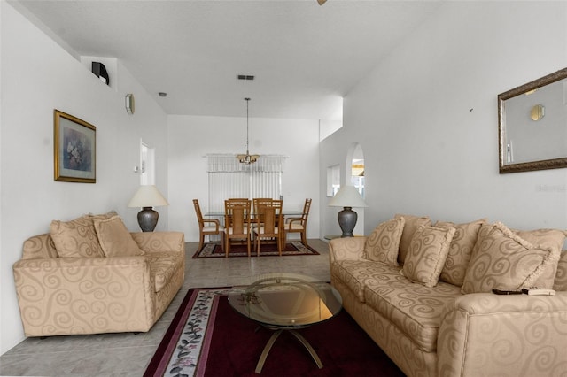 living room with light tile patterned floors and an inviting chandelier