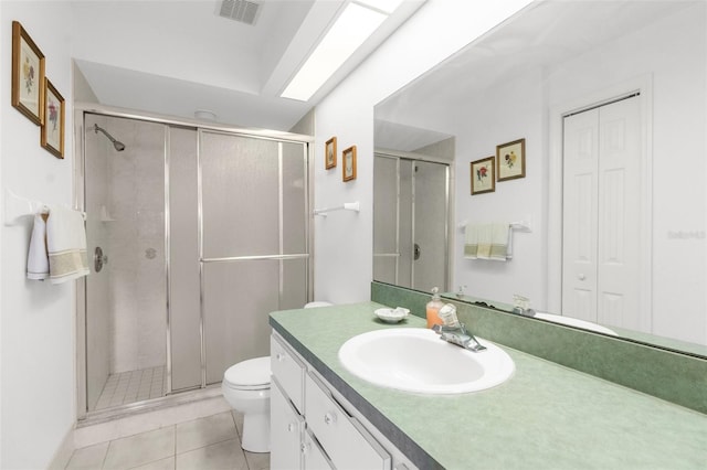 bathroom featuring a shower with door, tile patterned floors, toilet, and vanity