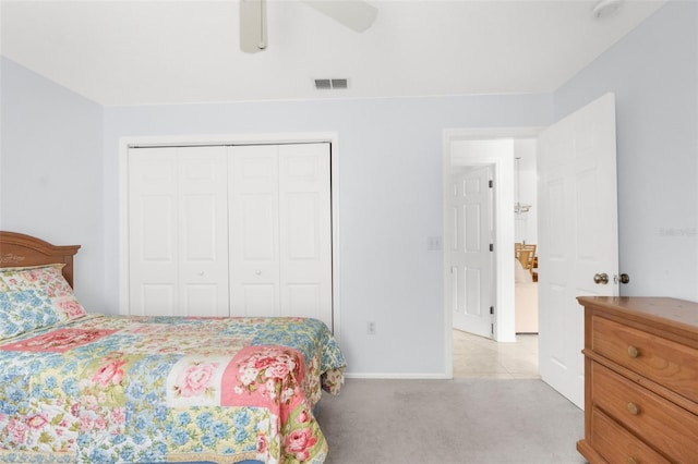 bedroom featuring ceiling fan, light carpet, and a closet