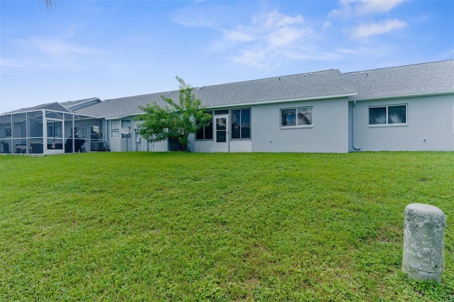 rear view of property with a lawn and a lanai