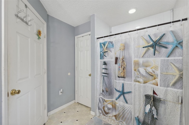 bathroom featuring tile patterned floors and a textured ceiling