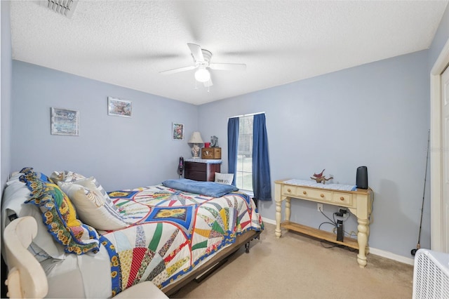 bedroom featuring light carpet, ceiling fan, and a textured ceiling