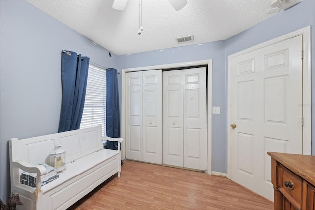 interior space featuring light hardwood / wood-style flooring, a textured ceiling, and ceiling fan