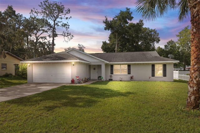 single story home with a garage and a yard