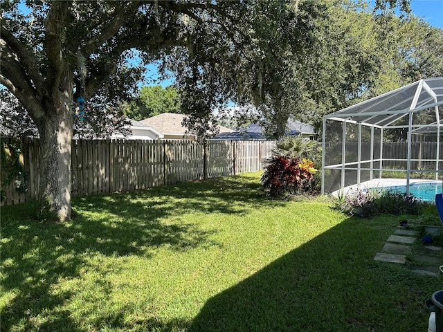 view of yard with glass enclosure and a fenced in pool