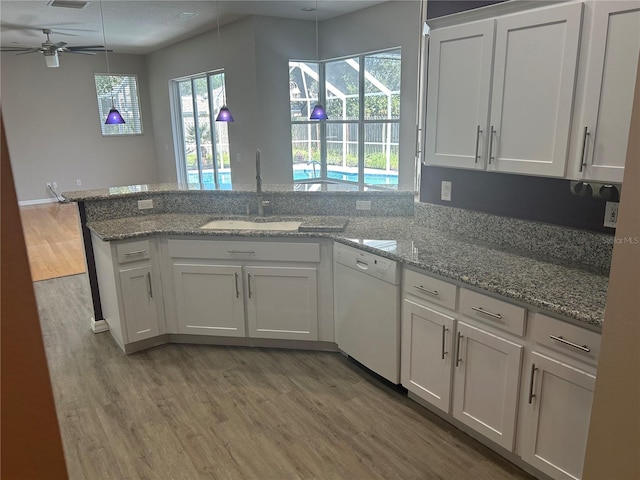 kitchen featuring ceiling fan, dishwasher, sink, and kitchen peninsula