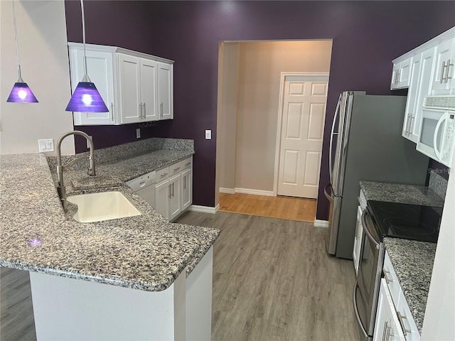 kitchen with white cabinets, sink, hanging light fixtures, light hardwood / wood-style floors, and stainless steel electric range oven