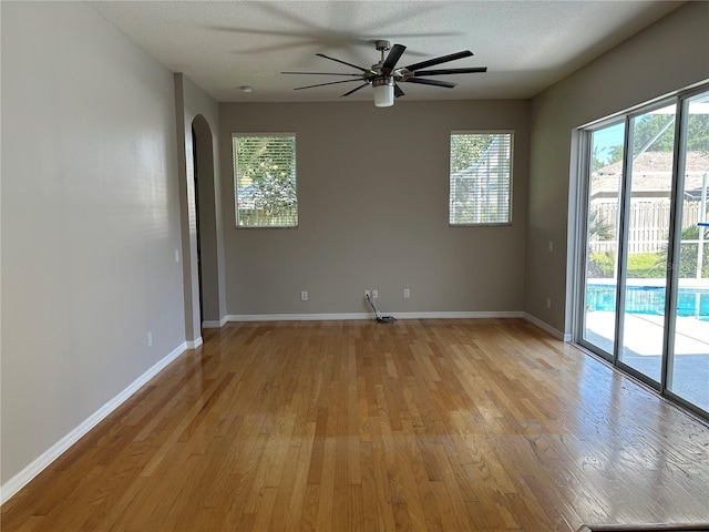 unfurnished room featuring a textured ceiling, light hardwood / wood-style flooring, and ceiling fan