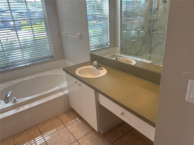 bathroom with tiled tub, tile patterned floors, and vanity