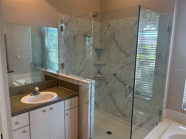 bathroom featuring a shower with door and vanity