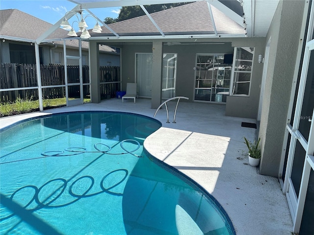 view of pool with a patio and glass enclosure