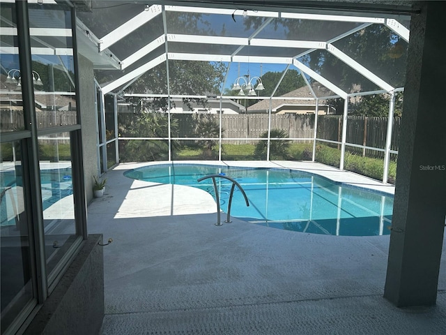 view of swimming pool featuring a patio and glass enclosure