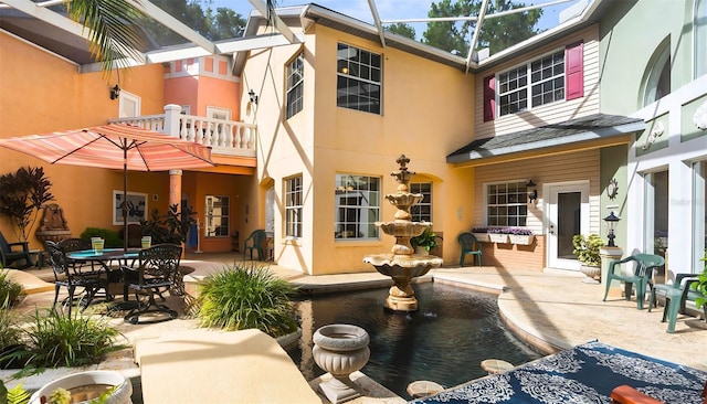 rear view of house with a patio, a lanai, and stucco siding