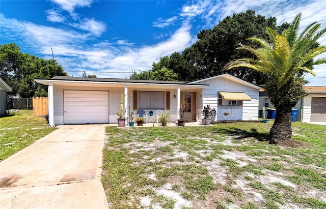 ranch-style house with covered porch, a front yard, and a garage