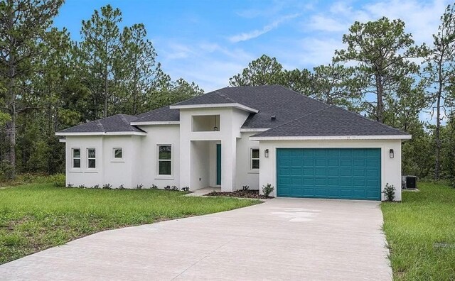 view of front of house with a garage, central AC unit, and a front yard